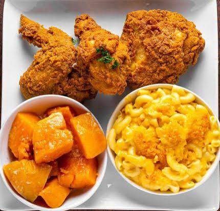Southern food spread with fried chicken, mac and cheese, collard greens and cornbread